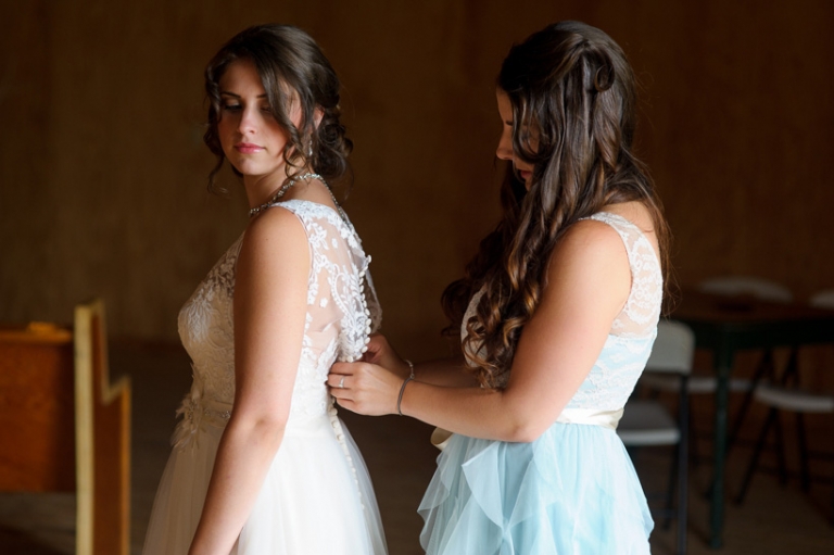 Bride putting on dress