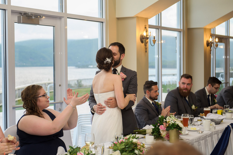Bride and groom kissing at head table