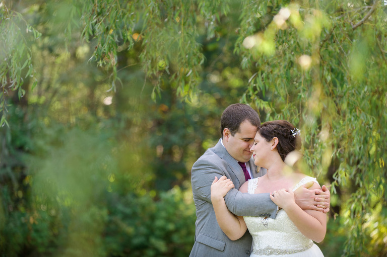 bride and groom under willow trees