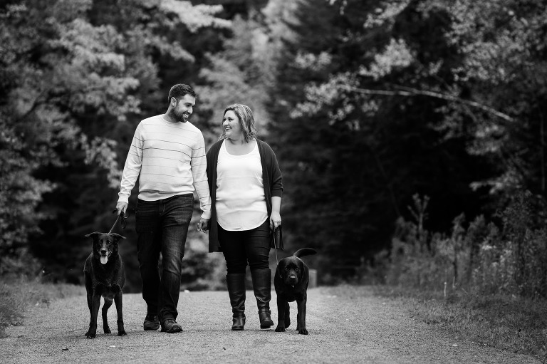 Couple walking with 2 black dogs