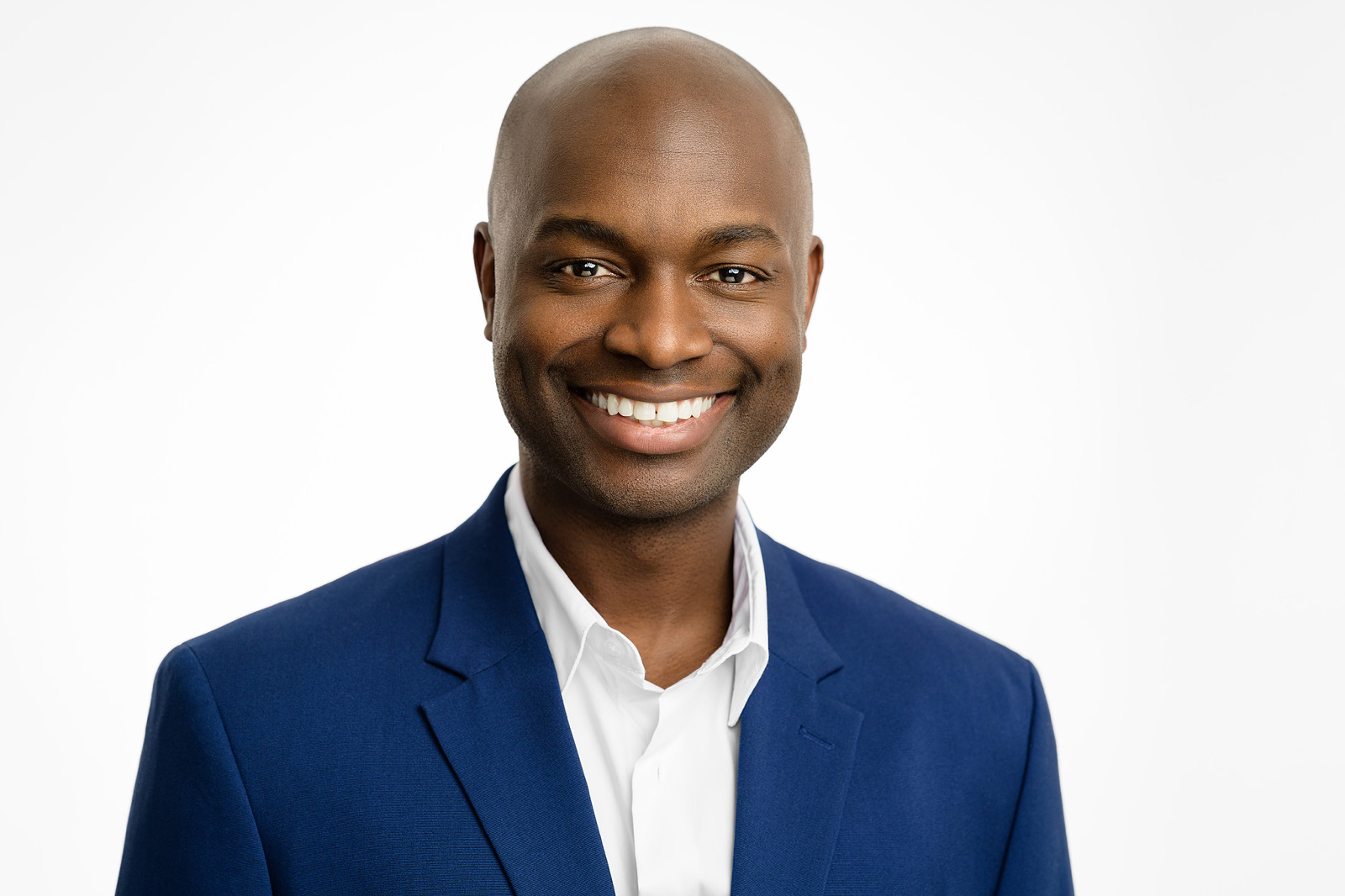 Headshot of a man wearing a blue blazer on a white background